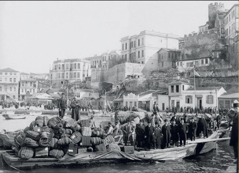 Black-and-white photograph of Greek refugees from Asia Minor disembarking with their bundled belongings at the waterfront of Thessaloniki, c. 1923.